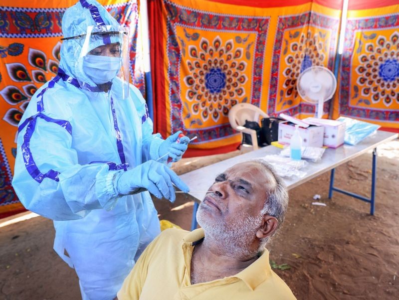 A corporation worker takes swab sample of a man for COVID-19 test at a government hospital in Coimbatore on May 31, 2021. (PTI Photo)