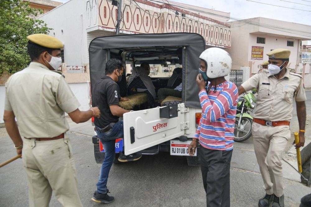 Ajmer: A police personnel nabs an offender amid a curfew in Ajmer, Rajasthan, Tuesday, May 4, 2021. (PTI Photo)