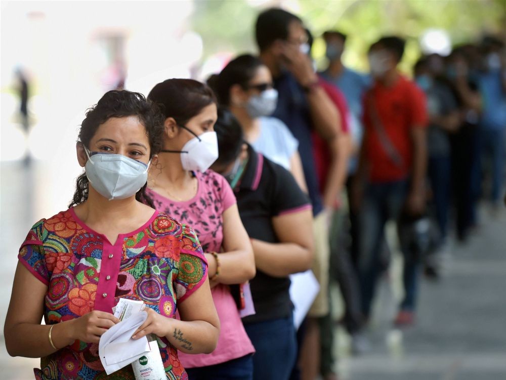 New Delh: People above 18 stand in a queue to receive the first dose of COVID-19 vaccine at a vaccination centre in a govt school, in New Delhi, Monday, May 3, 2021.  The third phase of the inoculation drive (18-45yrs) of vaccine began today. (PTI Photo/Manvender Vashist)