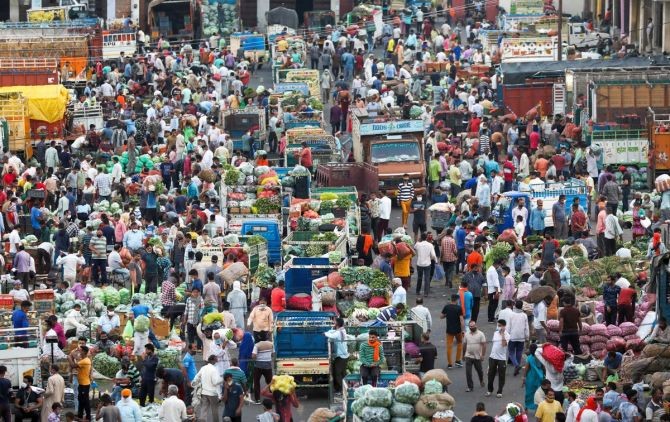 People, not adhering to social distancing norms, gather to purchase vegetables at Narwal wholesale vegetable and fruit market in Jammu. (PTI Photo)