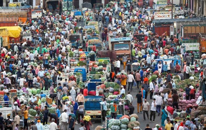 People,  not adhering to social distancing norms, gather to purchase vegetables at Narwal wholesale vegetable and fruit market in Jammu. (PTI Photo)