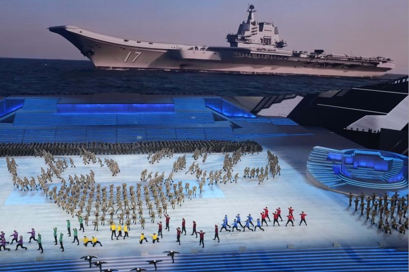 China's military members perform near a display showing the navy's aircraft carrier in a segment of a gala show ahead of the 100th anniversary of the founding of the Chinese Communist Party in Beijing on June 28, 2021. China is marking the centenary of its ruling Communist Party this week by heralding what it says is its growing influence abroad, along with success in battling corruption at home.. (AP/PTI Photo)