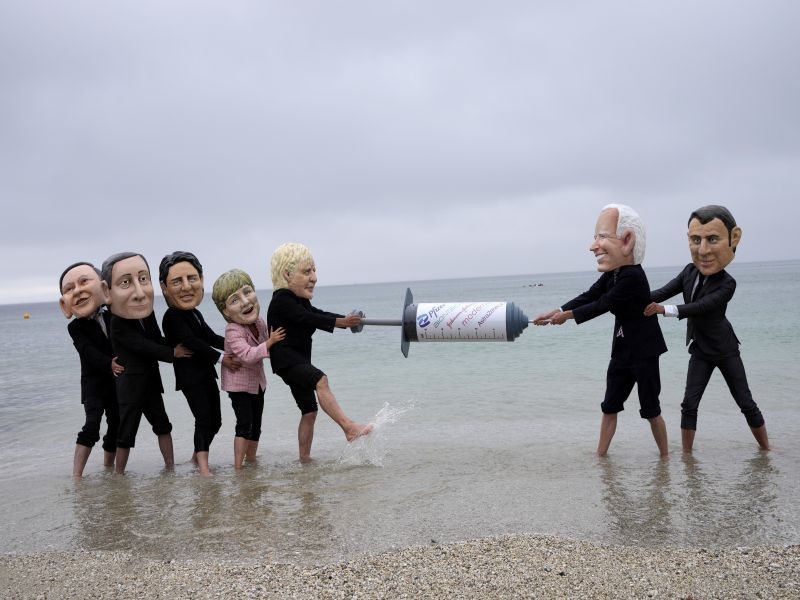 Activists wearing giant heads of the G7 leaders tussle over a giant COVID-19 vaccine syringe during an action of NGO's on Swanpool Beach in Falmouth, Cornwall, England, Friday, June 11, 2021. Leaders of the G7 begin their first of three days of meetings on Friday in Carbis Bay, in which they will discuss COVID-19, climate, foreign policy and the economy. Depicted from left to right, Japan's Prime Minister Yoshihide Suga, Italy's Prime Minister Mario Draghi, Canadian Prime Minister Justin Trudeau, German Chancellor Angela Merkel, British Prime Minister Boris Johnson, U.S. President Joe Biden and French President Emmanuel Macron. AP/PTI