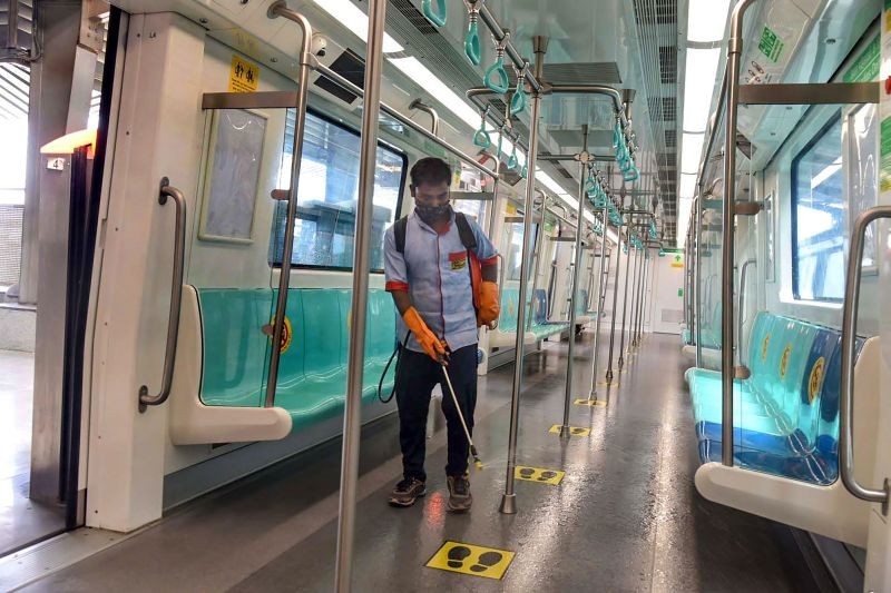 Noida: A worker sprays disinfectant inside a metro as Noida Metro Rail Corporation (NMRC) services to resume after unlocking process of Covid-19 lockdown began in graded manner, in Noida, Tuesday, June 8, 2021. (PTI Photo)