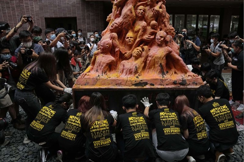 University students clean the "Pillar of Shame" statue, a memorial for those killed in the 1989 Tiananmen crackdown, at the University of Hong Kong on June 4, 2021. Police arrested an organizer of Hong Kong's annual candlelight vigil remembering the deadly Tiananmen Square crackdown and warned people not to attend the banned event Friday as authorities mute China's last pro-democracy voices. (AP/PTI Photo)