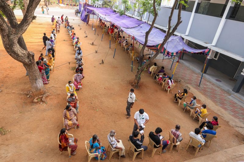 People wait to recieve the token for Covid-19 vaccine at the Ramanathapuram health care centre in Coimbatore on June 23. (PTI Photo)