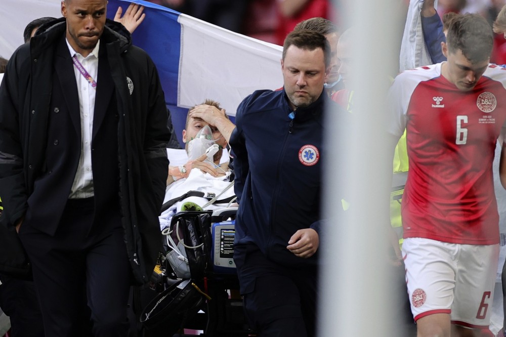 Paramedics using a stretcher to take out of the pitch Denmarks Christian Eriksen after he collapsed during the Euro 2020 soccer championship group B match between Denmark and Finland at Parken stadium in Copenhagen, Denmark on June 12. (AP/PTI Photo)