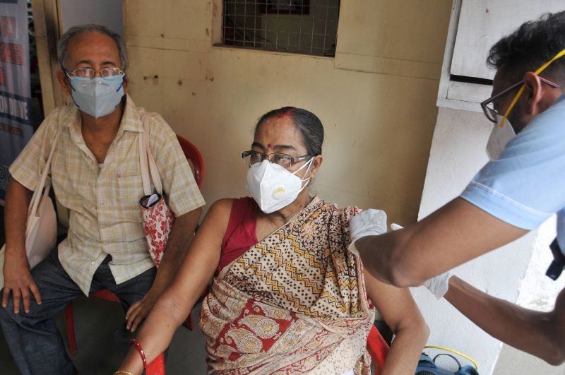 A medic administers COVID 19 vaccine to a elderly woman beneficiary during vaccination drive, arranged by Sourav Ganguly Foundation (SGF), near his residence in Kolkata on June 13. (PTI Photo)