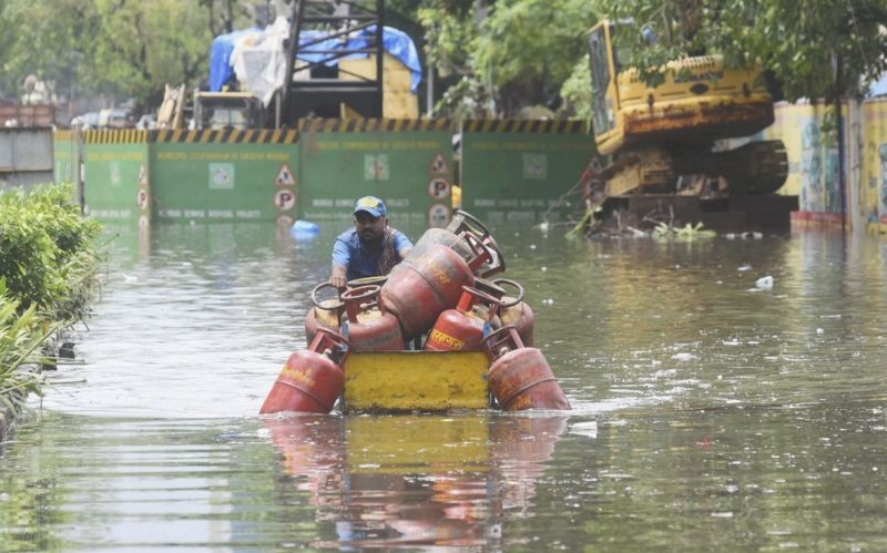Mumbai: A LPG cylinder supplier wades through waterlogged S V Road after heavy rain, at Khar West in Mumbai, Saturday, June 12, 2021. (PTI Photo)