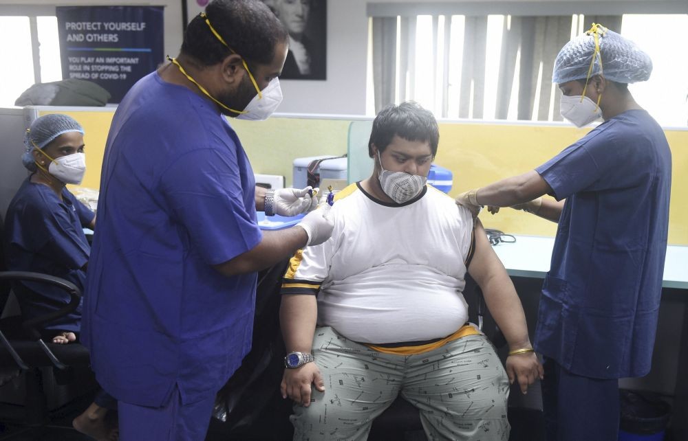 A health worker administers a dose of a COVID-19 vaccine to a beneficiary, during a vaccination drive for people with a disability, at National Society for Equal Opportunities for the Handicapped India in Mumbai, Sunday, June 20, 2021.  (PTI Photo/Shashank Parade