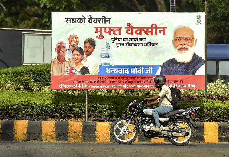 A commuter rides past a banner publicising govt’s vaccination drive, and thanking Prime Minister Narendra Modi, in New Delhi on June 23, 2021. (PTI Photo)