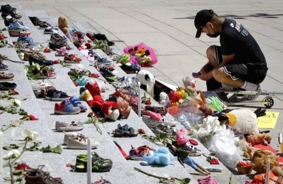 A resident attends a memorial event for the 215 children whose remains have been found buried at a former Kamloops residential school outside Vancouver Art Gallery in Vancouver, British Columbia, Canada. (IANS Photo)