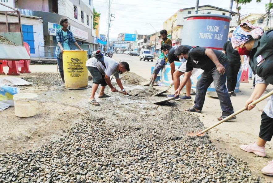 The team for Dimapur 24x7 filling up potholes at the traffic police point area near Zeliangrong village, Dhobinala. (Photo Courtesy: Dimapur 24x7)