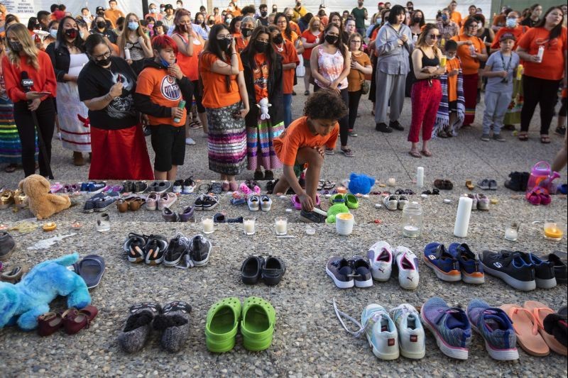 People gather and shoes are left in recognition of the discovery of more than 200 children's remains at the site of a former residential school in Kamloops, British Columbia, in Edmonton, Alberta, on May 31, 2021. (AP/PTI Photo)