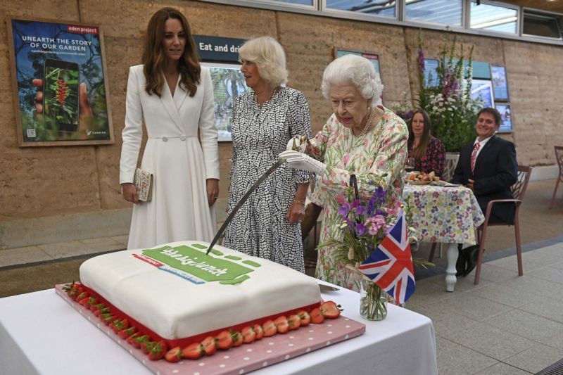 Cornwall: Britain's Queen Elizabeth II, centre, cuts a cake as Camilla, the Duchess of Cornwall, background centre and Kate, the Duchess of Cambridge stand by, as they attend an event in celebration of 'The Big Lunch 'initiative, during the G7 summit in Cornwall, England, Friday June 11, 2021. AP/PTI