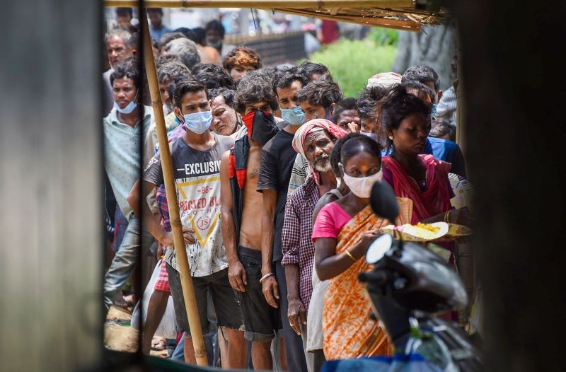 Needy people wait in a queue for free food distributed by a volunteer, during COVID-19 lockdown in Guwahati on June 4, 2021. (PTI Photo)