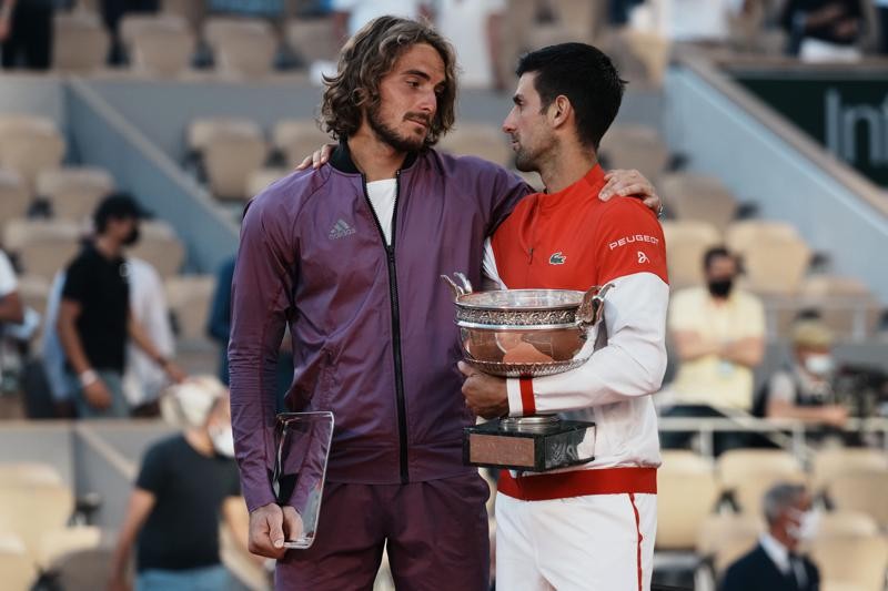 Serbia's Novak Djokovic, right, and Stefanos Tsitsipas of Greece hug while holding their trophies after their final match of the French Open tennis tournament at the Roland Garros stadium Sunday, June 13, 2021 in Paris. Djokovic won 6-7 (6), 2-6, 6-3, 6-2, 6-4. (AP Photo/Thibault Camus)