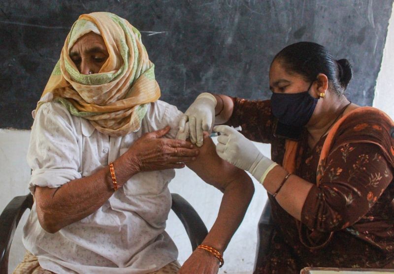 A health worker administers a dose of COVID-19 vaccine to a woman, at a vaccination centre in Gurugram on June 14, 2021. (PTI Photo)