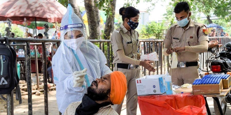 A medic collects a swab sample from a man for Covid-19 testing, in New Delhi. (Photo PTI)