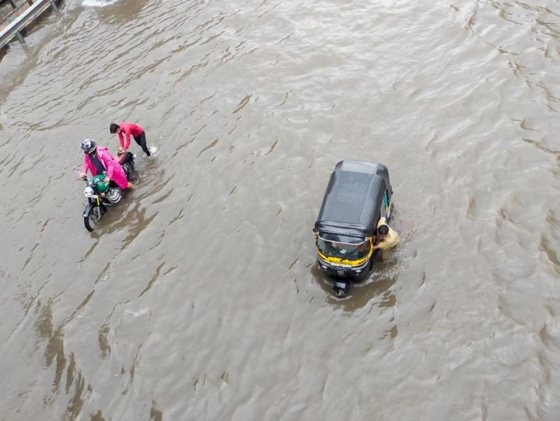 Mumbai: Commuters push their vehicles through a waterlogged street as heavy rain continues in Mumbai, Saturday, June 12, 2021. (PTI Photo/Kunal Patil)
