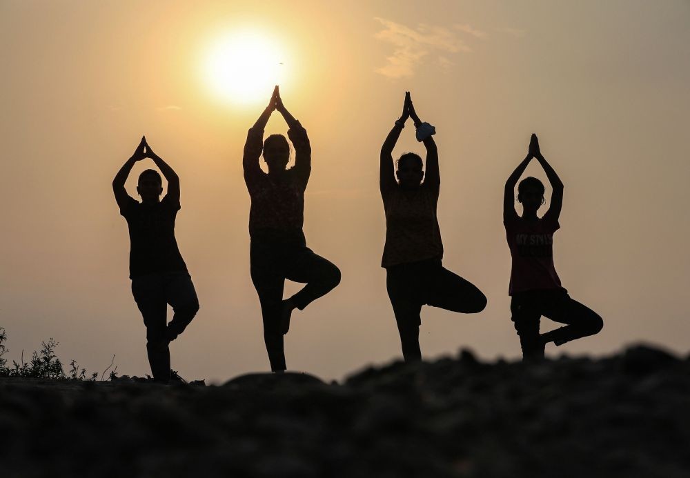 Jammu: Morning walkers perform yoga at Manda village ahead of International Yoga Day, in Jammu, Sunday, June 20, 2021. (PTI Photo)