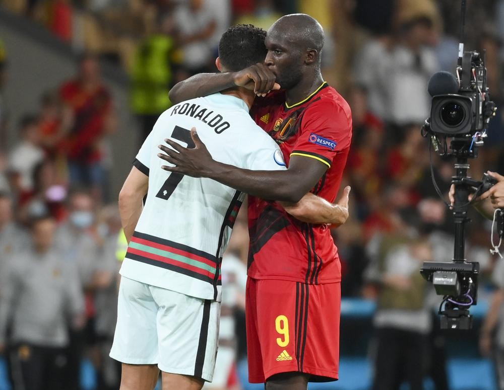 Belgium's Romelu Lukaku embraces Portugal's Cristiano Ronaldo, left, following the Euro 2020 soccer championship round of 16 match between Belgium and Portugal at La Cartuja stadium, Seville, Spain, Sunday, June 27, 2021. (Lluis Gene/Pool Photo via AP)