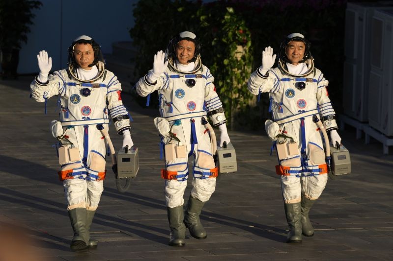 Chinese astronauts, from left, Tang Hongbo, Nie Haisheng, and Liu Boming wave as they prepare to board for liftoff at the Jiuquan Satellite Launch Center in Jiuquan in northwestern China on June 17, 2021. China plans on Thursday to launch three astronauts onboard the Shenzhou-12 spaceship who will be the first crew members to live on China's new orbiting space station Tianhe, or Heavenly Harmony. (AP/PTI Photo)