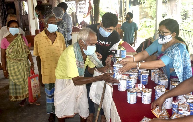 Volunteers distribute food and medicine among the needy people at Hatimari village in Malda district on June 20,  2021. (PTI Photo)