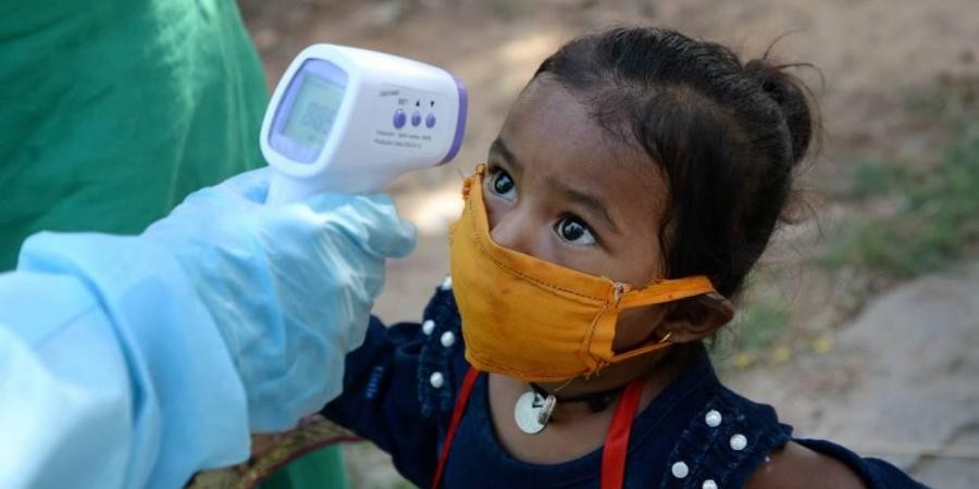 A medic screens a child of a migrant worker as they wait to board a train to Jharkhand during the ongoing COVID-19 nationwide lockdown in Jalandhar. (File Photo | PTI)