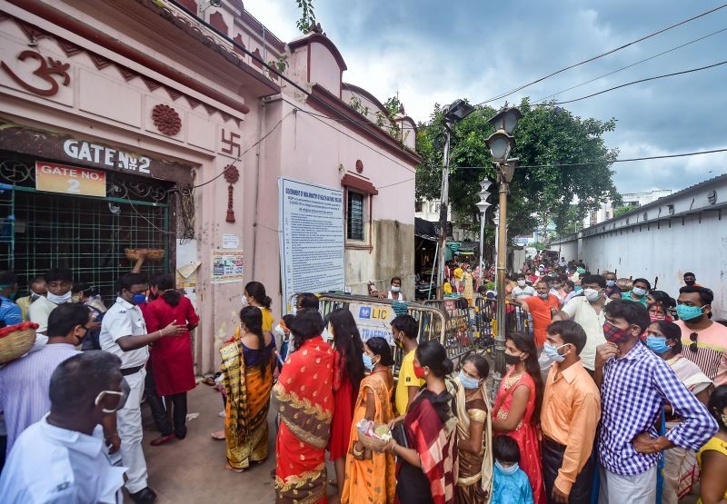 Devotees flout social distancing norms as they stand in queues to enter Kali temple at Kalighat for offering prayers on the occasion of 'Bipodtarini Puja', after authorities eased some Covid-19 induced lockdown restrictions in Kolkata on July 13. (PTI Photo)
