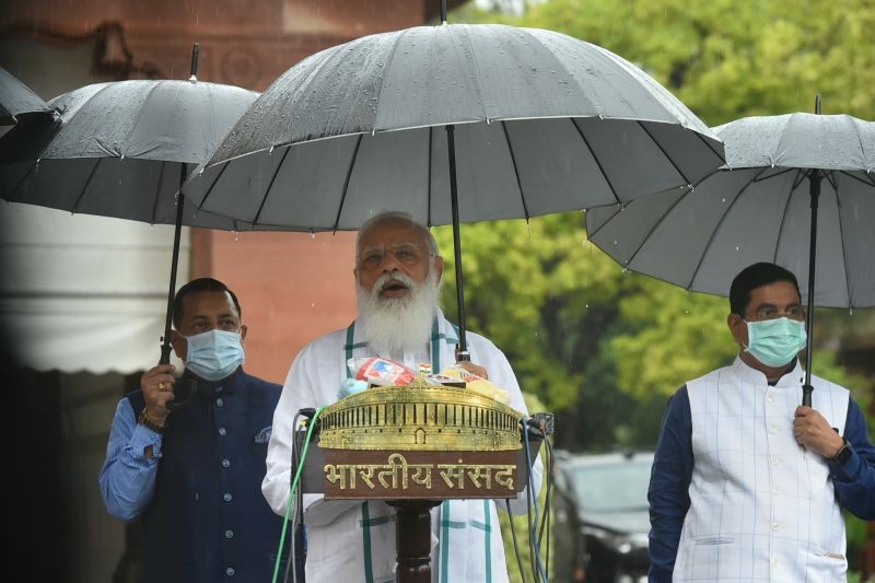 Prime Minister Narendra Modi addresses the media, as it rains on the first day of the Monsoon Session of Parliament, in New Delhi on July 19, 2021. Union Ministers Prahlad Joshi and Jitendra Singh are also seen. (PTI Photo)
