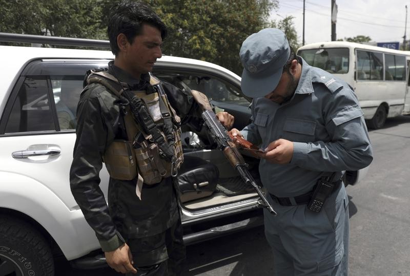 An Afghan policeman checks the documentation of a gun owner, at a temporary checkpoint in Kabul, Afghanistan on July 4, 2021. (AP File Photo)