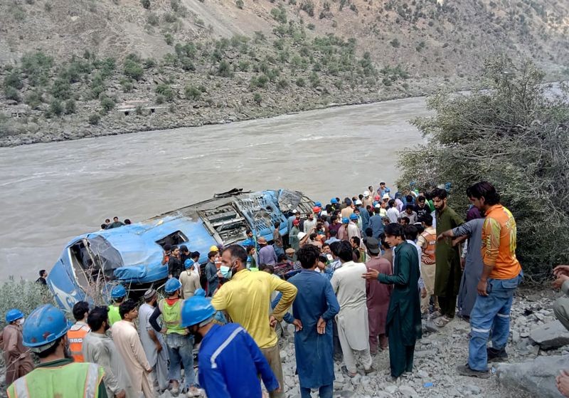 Local residents and rescue workers gather at the site of bus accident, in Kohistan Kohistan district of Pakistan's Khyber Pakhtunkhwa province on July 14, 2021. A bus carrying Chinese and Pakistani construction workers on a slippery mountainous road in northwest Pakistan fell into a ravine Wednesday, killing a dozen of people, including Chinese nationals, and dozens were injured, a government official said. (AP/PTI Photo)