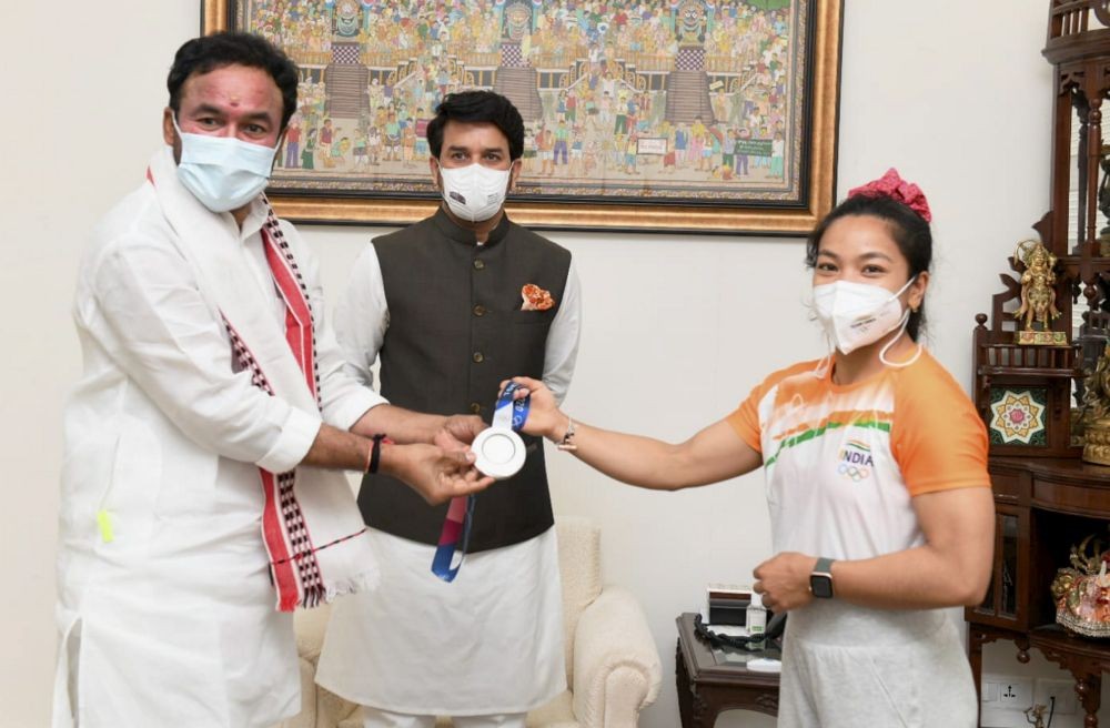 EDS: HANDOUT PHOTO MADE AVAILABLE FROM PIB SPORTS ON MONDAY, JULY 26, 2021.** New Delhi: Union Ministers Anurag Thakur and G kishan Reddy with Silver medalist in Tokyo Olympics, Weighlifter Saikhom Mirabai Chanu during her felicitation ceremony in New Delhi. (PTI Photo)