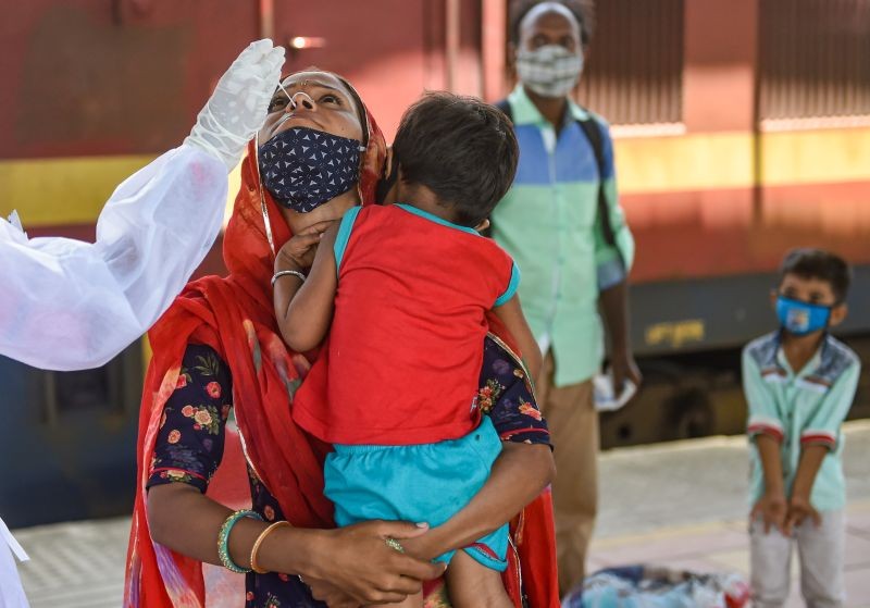 A BMC health worker collects swab sample of a passenger for COVID-19 test, at a station in Mumbai on July 2, 2021. India's official death toll from the coronavirus crossed 4,00,000. (PTI Photo)