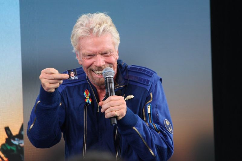 Truth or Consequences: Richard Branson holds up a photograph of CBS "Late Show" host Stephen Colbert during a news conference after Branson and five crewmates from his Virgin Galactic space-tourism company reached the edge of space following a launch near Truth or Consequences, N.M., on Sunday, July 11, 2021. Colbert served as master of ceremonies for the launch from Spaceport America. AP/PTI