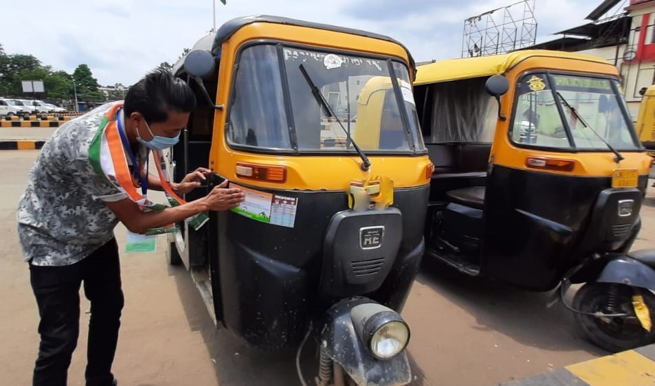 A Congress worker pastes sticker in an autorickshaw during the launching of 10-day campaign against price rise on July 7. (Photo Courtesy: NPCC)