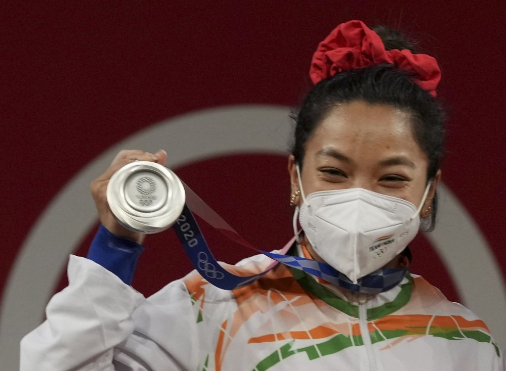 Tokyo: India's Mirabai Chanu poses for photographs while standing on the podium after receiving the silver medal in women's 49 kg category weightlifting event at the Summer Olympics 2020, in Tokyo, Saturday, July 24, 2021. (PTI Photo/Gurinder Osan)