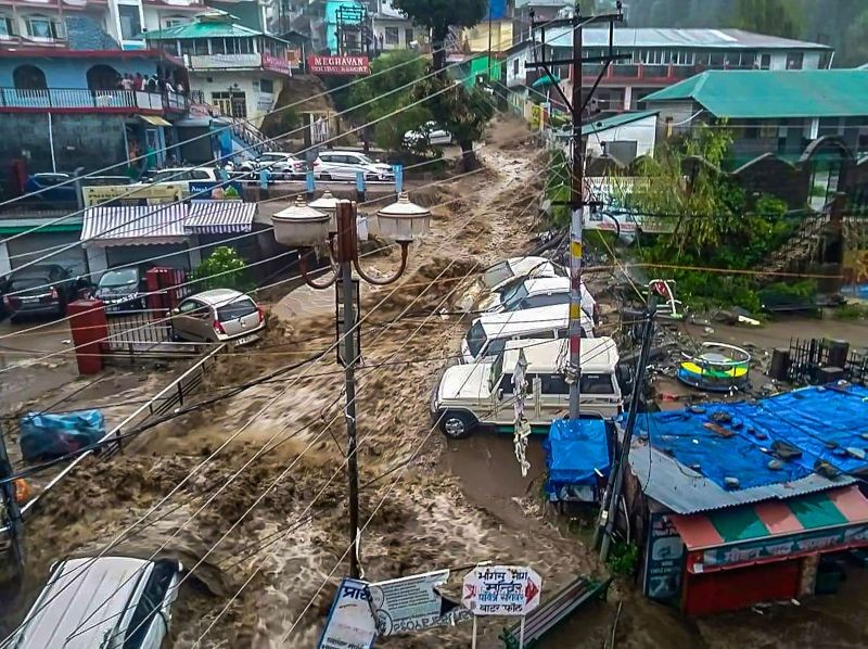 Flood water surges through a street amid heavy rain after a cloudburst, at Mcleodganj near Dharamshala on July 12, 2021. (PTI Photo)