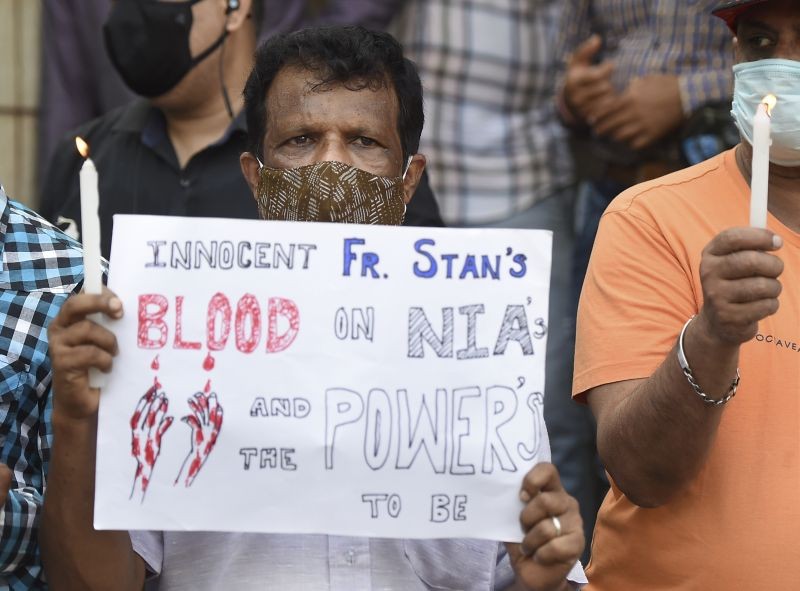 People hold posters and candles outside the church holding memorial for the human rights activist and Jesuit priest Father Stan Swamy, in Mumbai on July 6, 2021. (PTI Photo)