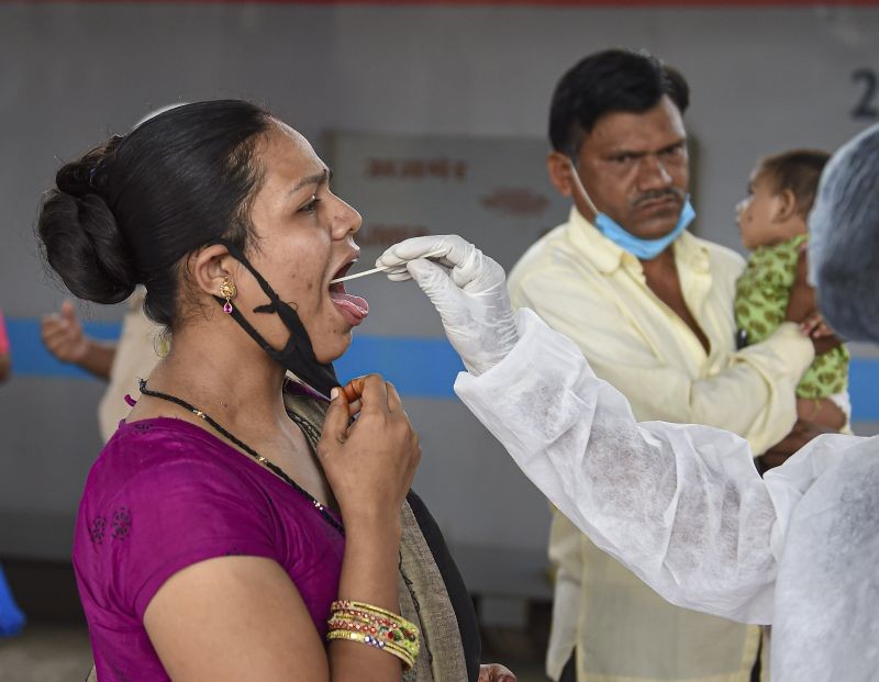 A health worker collects swab sample of a passenger for COVID-19 test, at Dadar railway station in Mumbai on July 29, 2021. (PTI Photo)