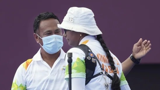 India's Deepika Kumari with coach Dharmendra Tiwary after winning in the women's individual 1/8 eliminations round of the archery event, at the Summer Olympics 2020.(PTI)