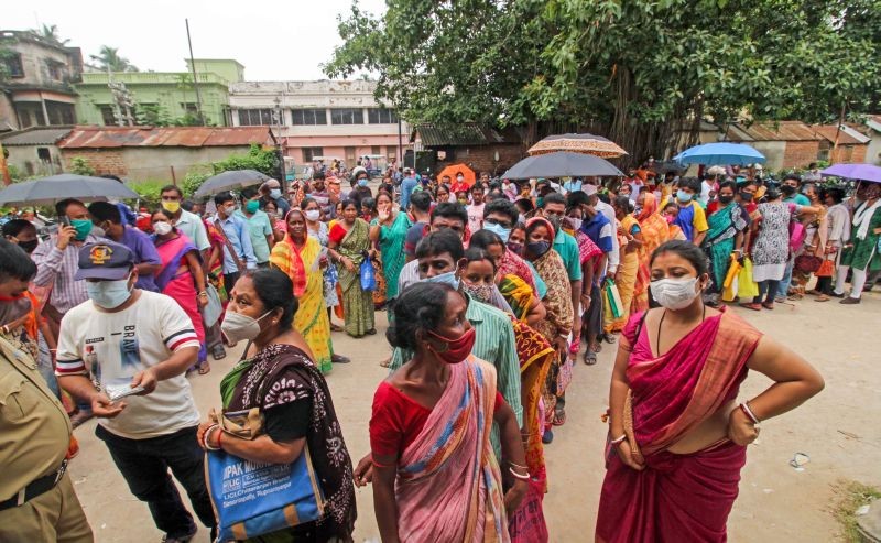 A policeman regulates beneficiaries as they wait in queues to receive COVID-19 vaccine dose, at a government vaccination centre in Birbhum district on July 26, 2021. (PTI Photo)