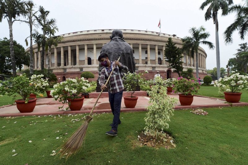 A worker sweeps the premises of Parliament House, a day before the monsoon session of Parliament begins, in New Delhi on July 18. (PTI Photo)