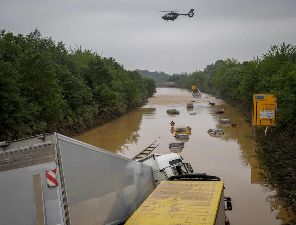 Cars show up as the flood sinks on a road in Erftstadt, Germany, Saturday, July 17, 2021. Due to strong rain falls the small Erft river went over the banks causing massive damages. (AP Photo/Michael Probst)