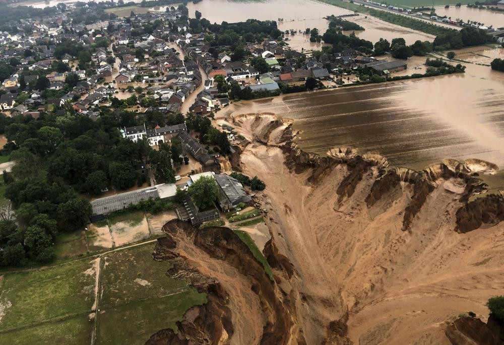 This image provided on Friday, July 16, 2021 by the Cologne district government shows the Blessem district of Erftstadt in Germany. Rescuers were rushing Friday to help people trapped in their homes in the town of Erftstadt, southwest of Cologne. Regional authorities said several people had died after their houses collapsed due to subsidence, and aerial pictures showed what appeared to be a massive sinkhole. (Rhein-Erft-Kreis via AP)