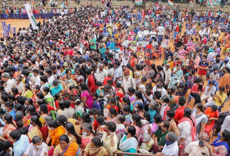Bengaluru: People flout social distancing norms to receive ration kit organised by former Congress mayor Padmavati at Rajajinagar in Bengaluru, Tuesday, Aug 10, 2021. (PTI Photo)