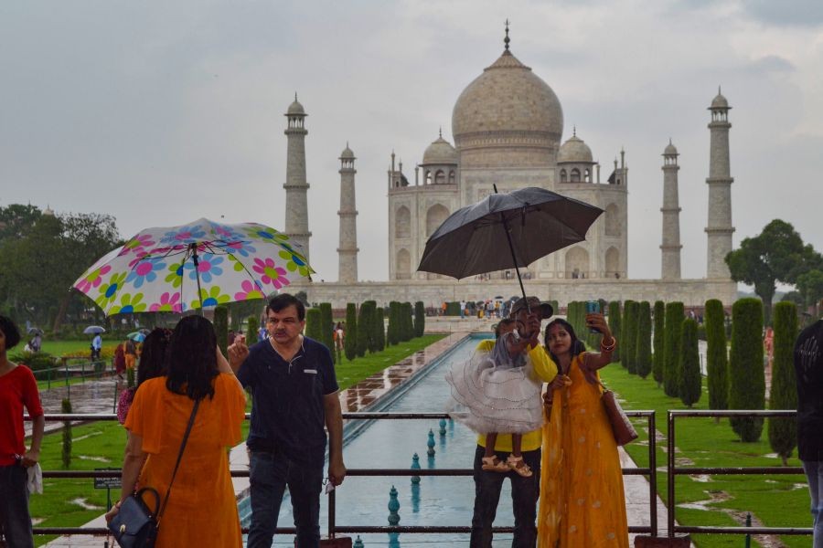 Agra: Visitors carry umbrella during rain at Taj Mahal in Agra, Saturday, Aug 21, 2021. (PTI Photo)