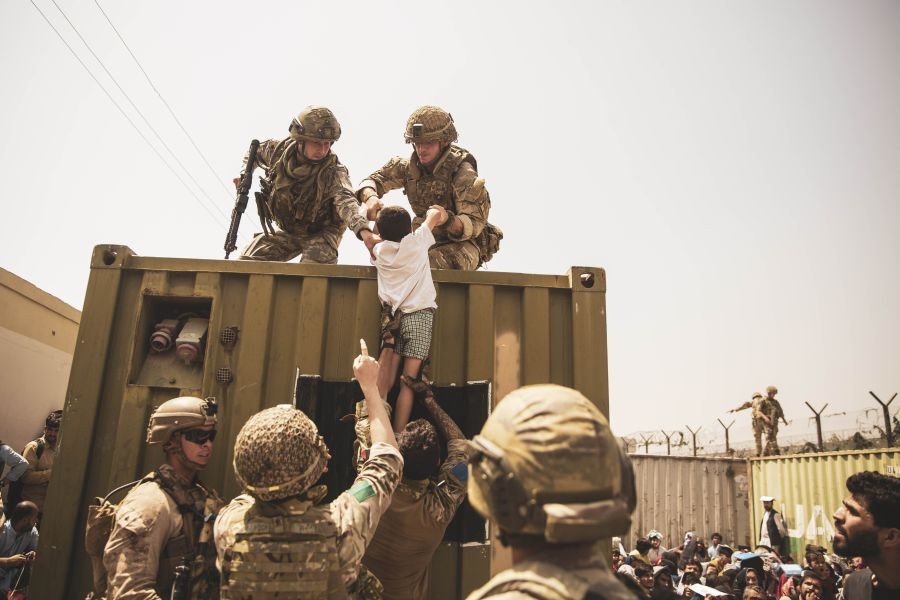Kabul: In this image provided by the U.S. Marine Corps, British and Turkish coalition forces, along with U.S. Marines, assist a child during an evacuation at Hamid Karzai International Airport in Kabul, Afghanistan, Friday, Aug. 20, 2021.AP/PTI Photo