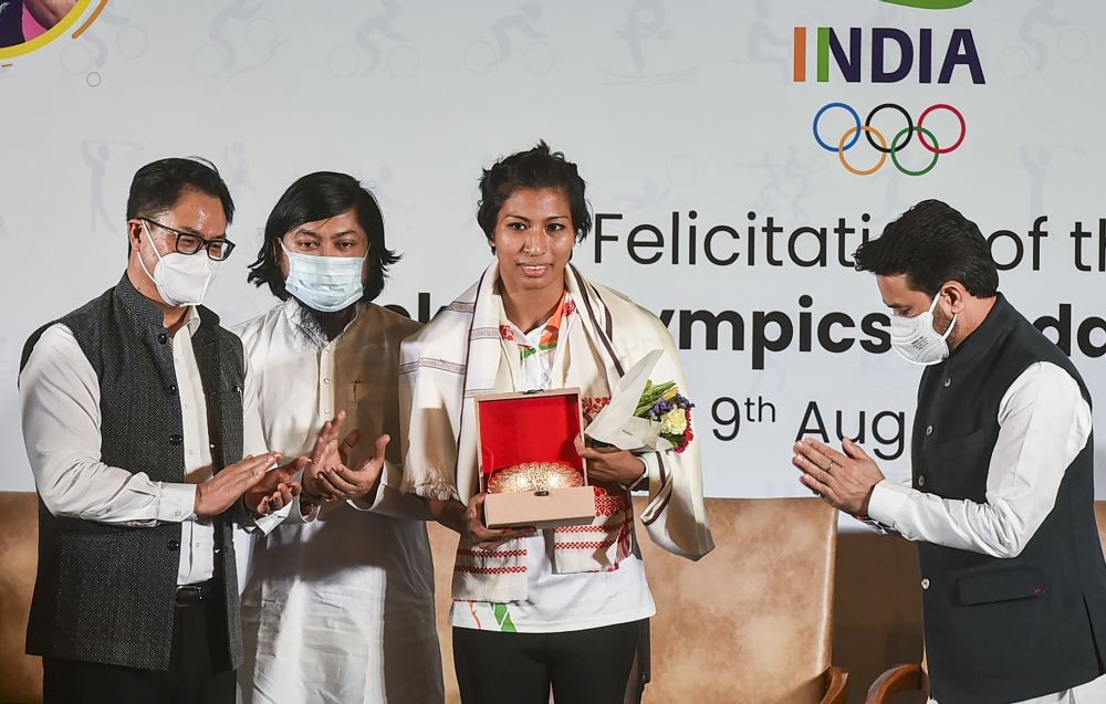 New Delhi: Union Ministers Anurag Thakur and Kiren Rijiju with Bronze medalist in Tokyo Olympics, boxer Lovlina Borgohain during her felicitation ceremony, in New Delhi, Monday, Aug 9, 2021. MoS for Home Affairs Nisith Pramanik is also seen. (PTI Photo/Arun Sharma)
